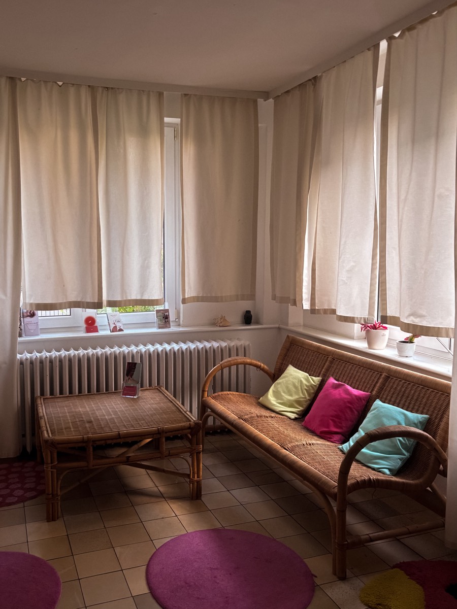 Sitzecke mit Rattanbank vor den Fenstern des Kursraums